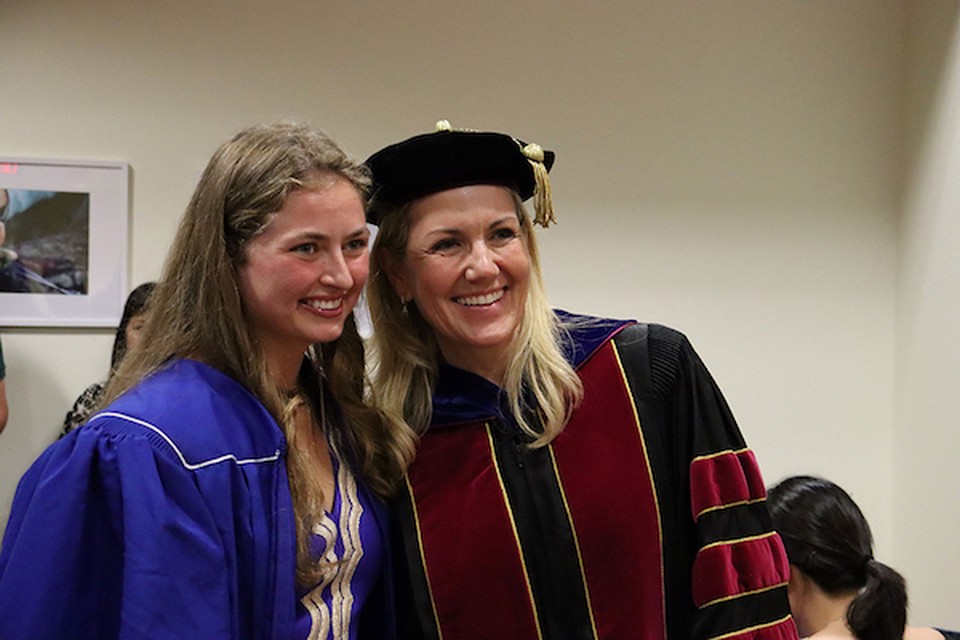 A professor and a student smiling