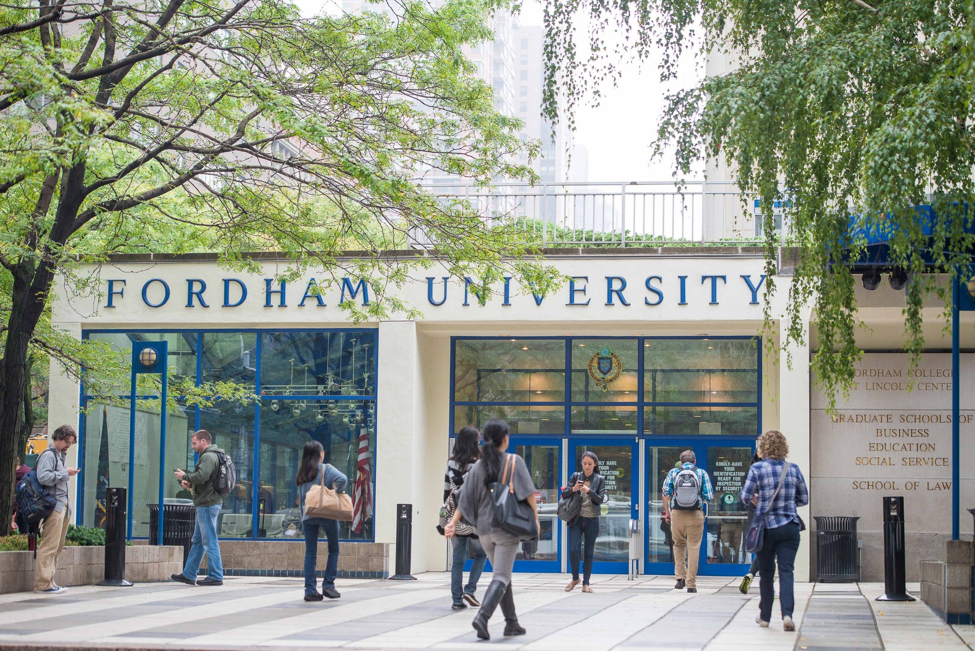 Students walking in and out of a graduate studies building at Fordham University