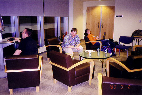 The lobby at the first Animarathon. Two people sit in comfy chairs. Another uses the tangerine orange lounge CRT all in one Computer.