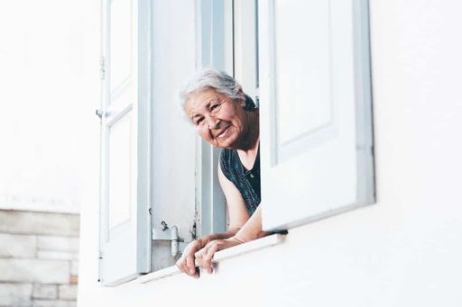 Smiling elderly woman looking out a window