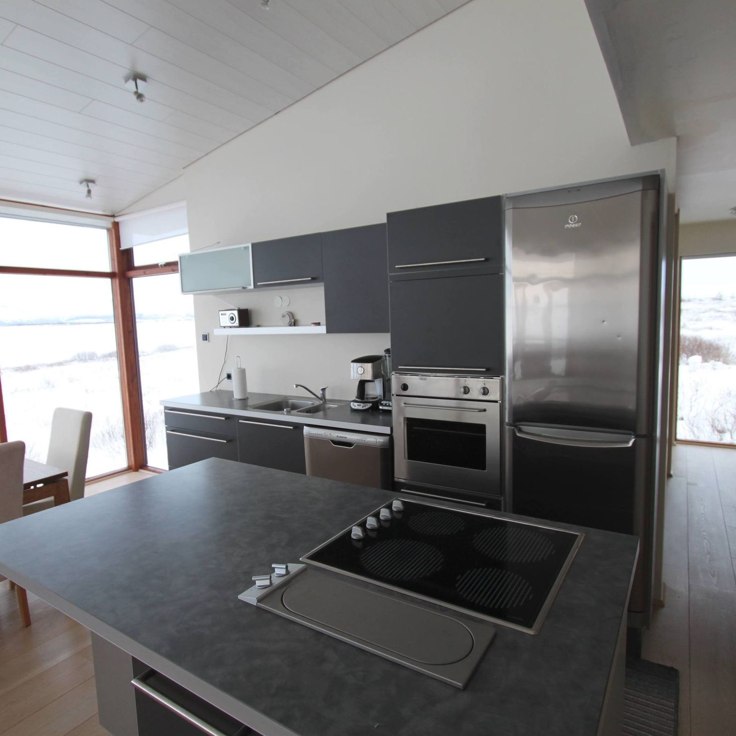 Stylishe, offene Küche mit großem Küchenblick und Panoramafenstern