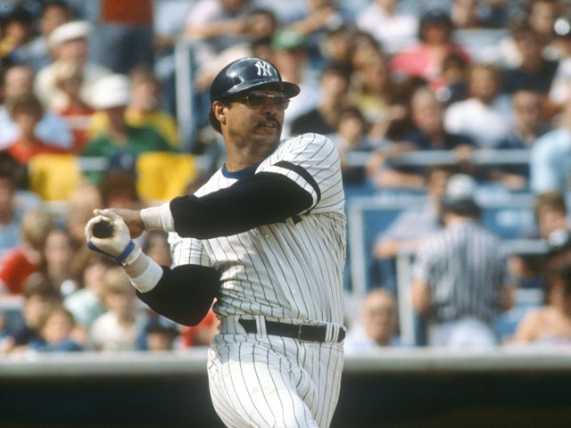 Reggie Jackson of the New York Yankees following through after a swing while wearing his eyeglasses