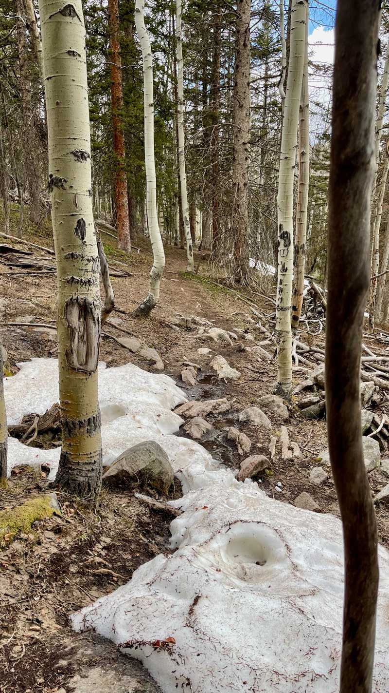 A rocky section of trail with patches of snow