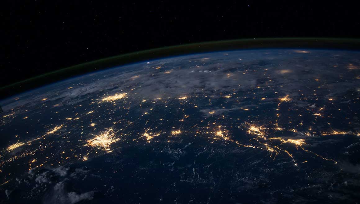 Image of the globe at night with the electric lights of metropolitan areas shining.