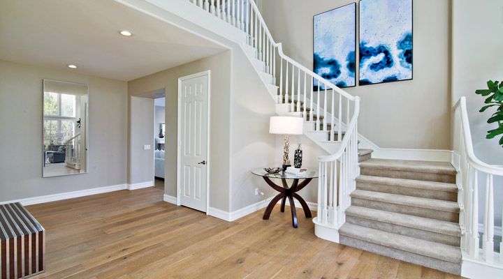 enlarged photo of staircase with white painted rails and a light grey painted wall