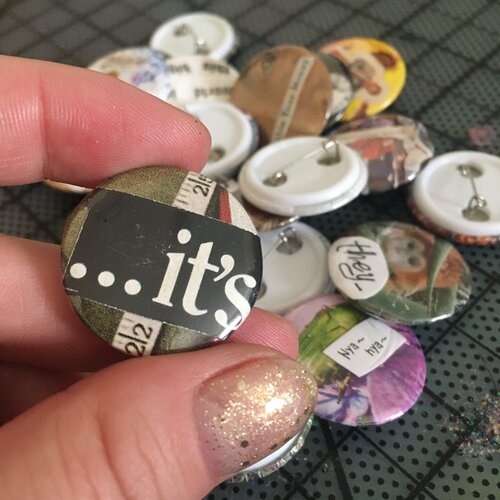 close up of collage pin reads 'its...'