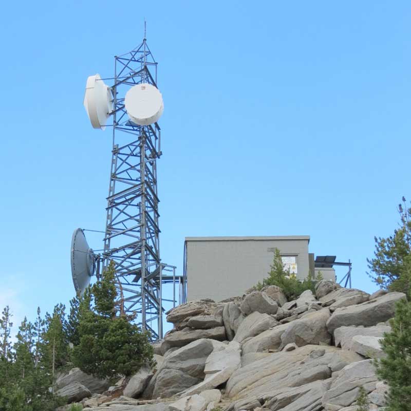 photo of communications tower and building on rocky slope