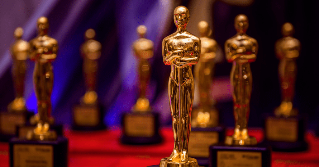 Image that shows Academy Award statues lined up on a red table