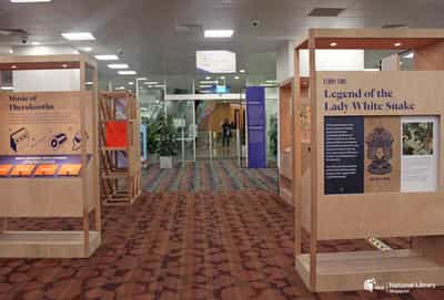 A photo of the roving exhibition. Several small wooden walls surround each other with information and interactive panels on it.