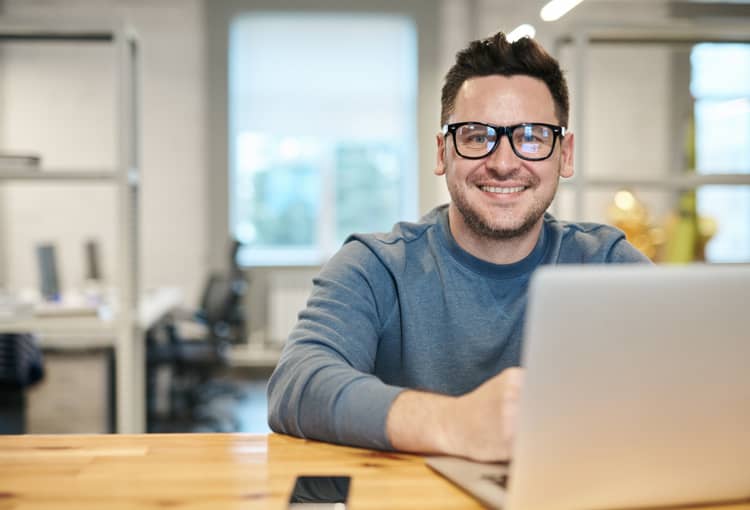 Mann mit Brille im Büro vor Laptop