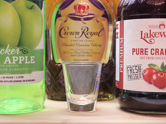 Washington Apple shot ingredients, including Crown Royal Canadian Whisky, Sour Apple Schnapps, and Cranberry Juice, along with a shot glass
