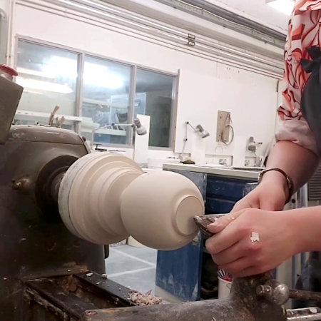 Refining the shape of the plaster model's foot.