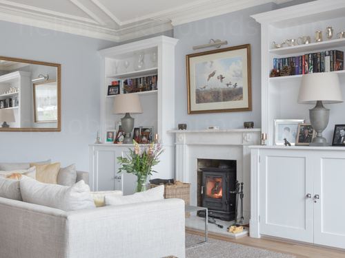 Sophisticated living room decorated with calm colours and featuring a fireplace with a wood burner Skype background