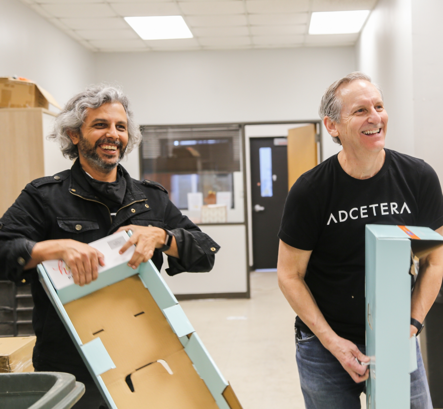 two Adcetera volunteers breaking down cardboard boxes