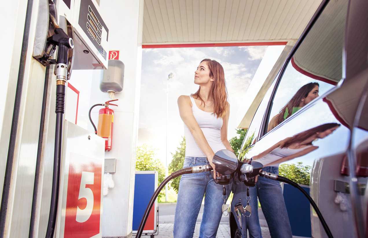 Woman using a fleet card to fill up her car with gas