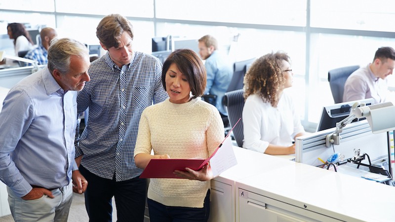 Staff standing in a busy open plan office