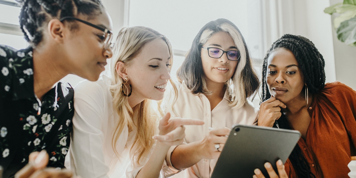 Outstanding Examples of Deign for and by Women Four women from diverse backgrounds gathered around a tablet, discussing an idea