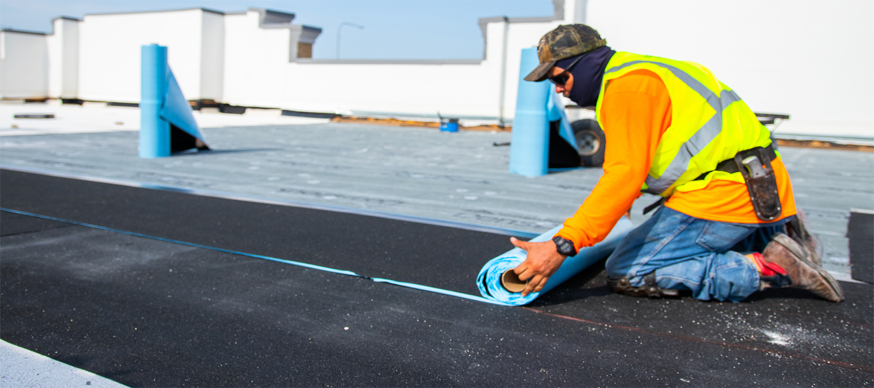 Construction Worker Installing Modified Bitumen MBR Roofing