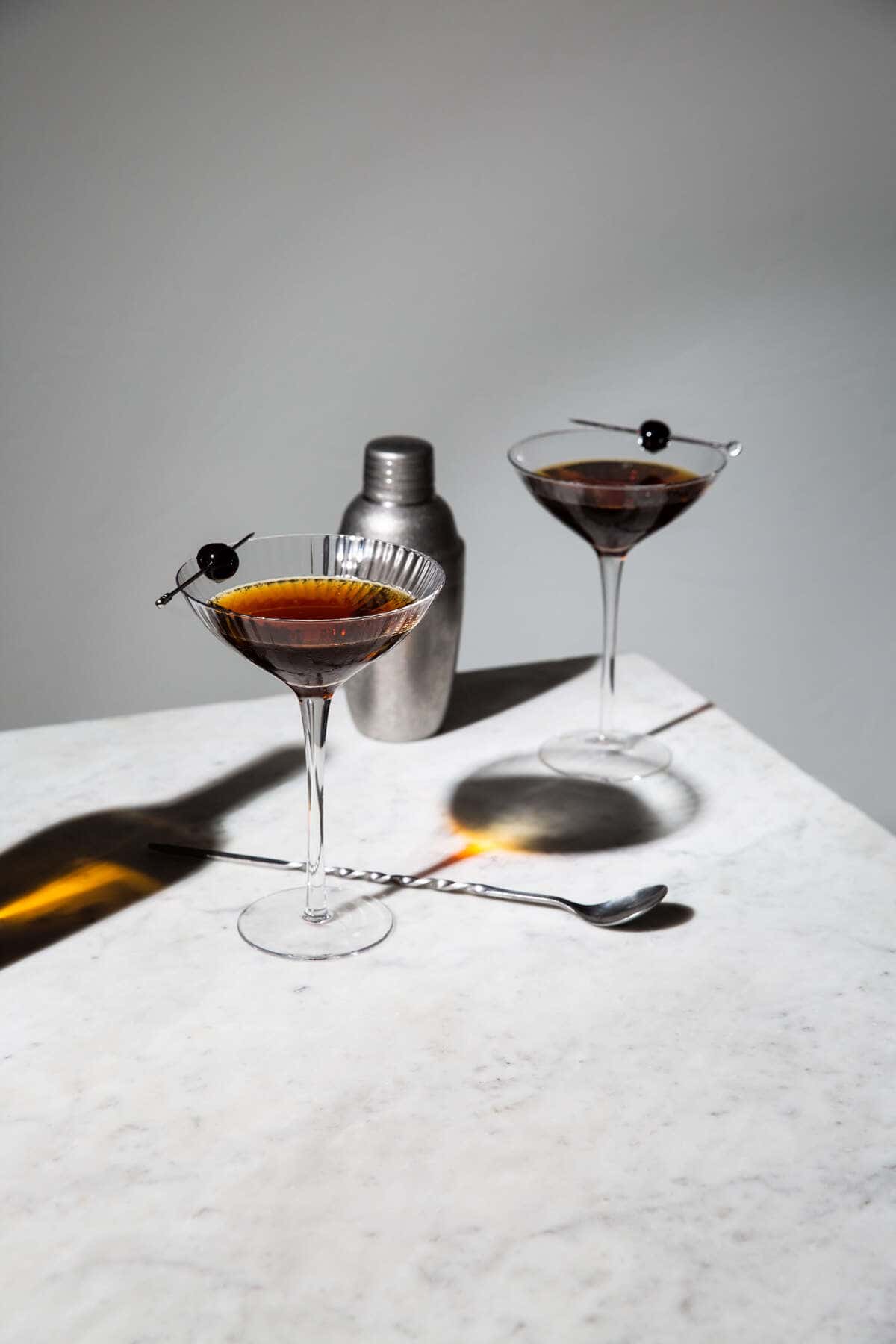 rob roy whisky cocktail in glasses set on marble
