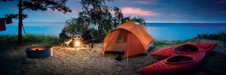 camping with tent and campfire and kayaks