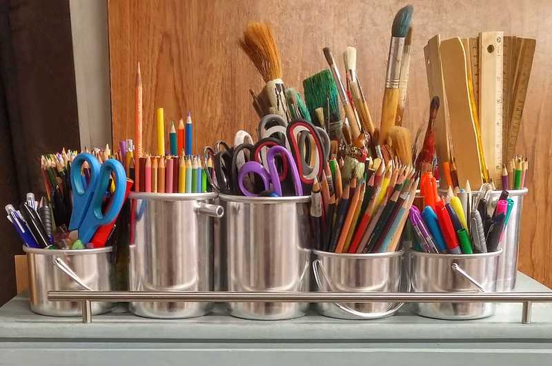 Photo of art supplies in stainless steel buckets.