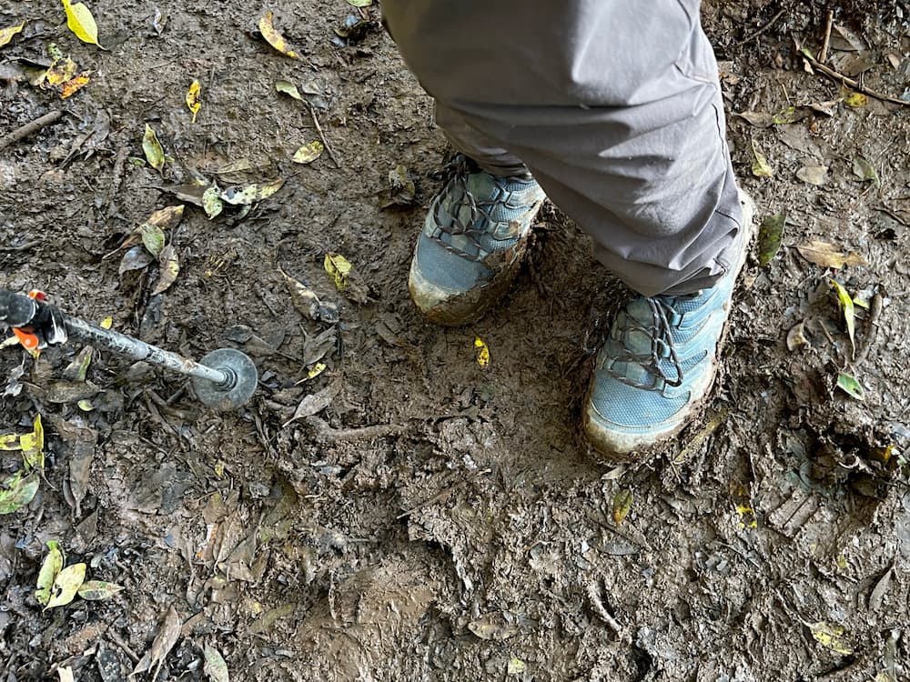 Scarpa hiking boots and Komperdell trekking poles on the muddy trail
