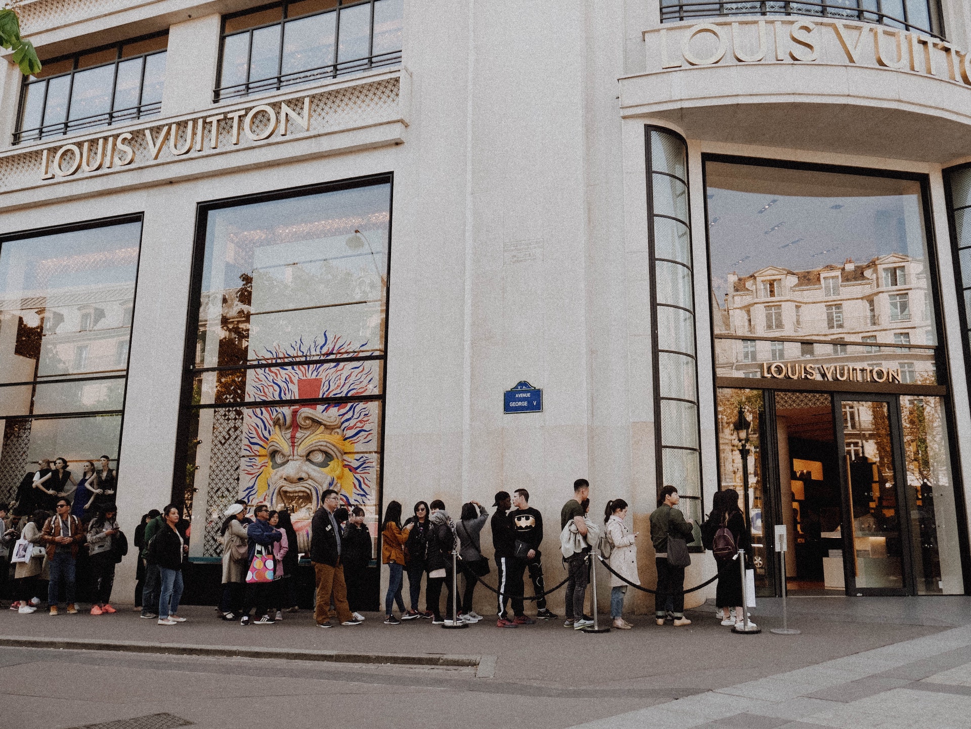 Customers lining up outside a Louis Vuitton store