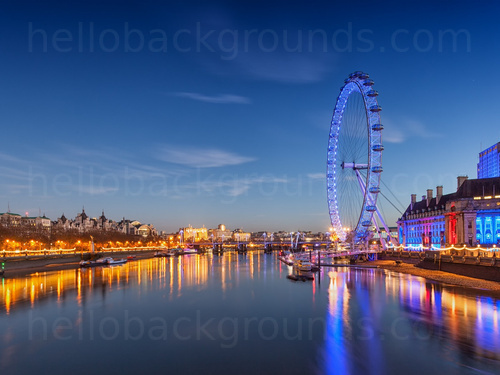 The London Eye lit up at dusk over a still river Thames reflecting city lights  Skype background