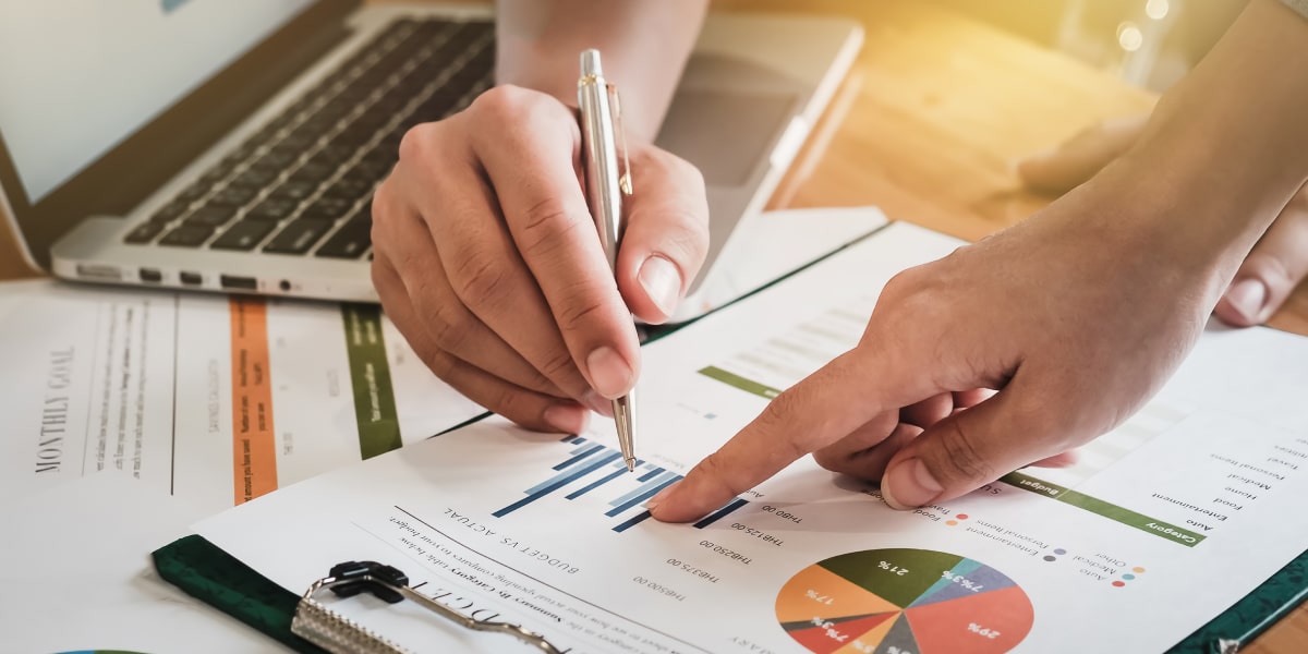 What are the best data visualization tools? A pair of hands pointing to a piece of paper with various charts and diagrams on it