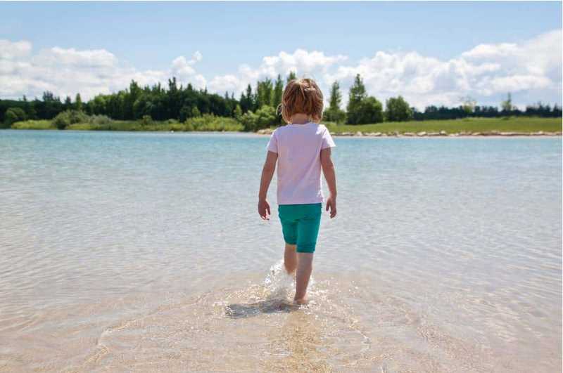 Child kicking water in Saskatchewan lake