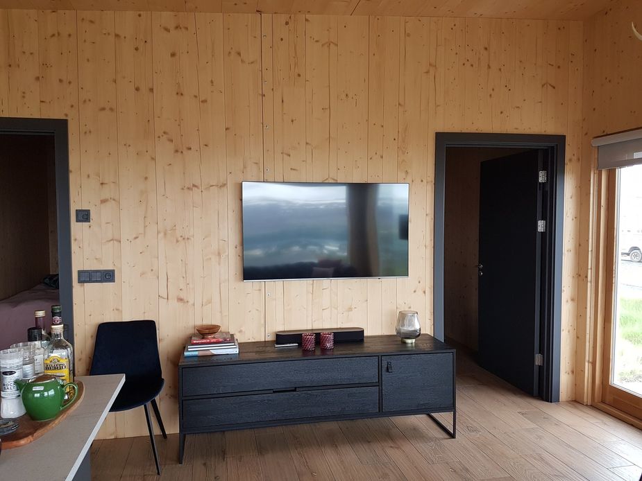 Im Wohnbereich befindet sich ein großer Flatscreen-TV an der Wand