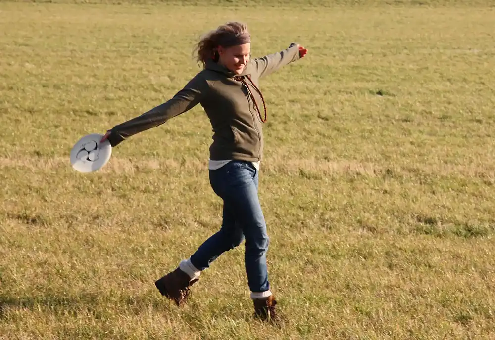 Woman in a field playing frisbee