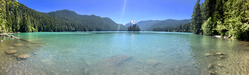 Panoramic view of an aqua lake with snow-capped mountains beyond