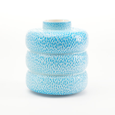 A mid-blue vessel made up of three donut-shaped sections and a short neck, with an all over incised texture that holds the blue glaze more intensely.