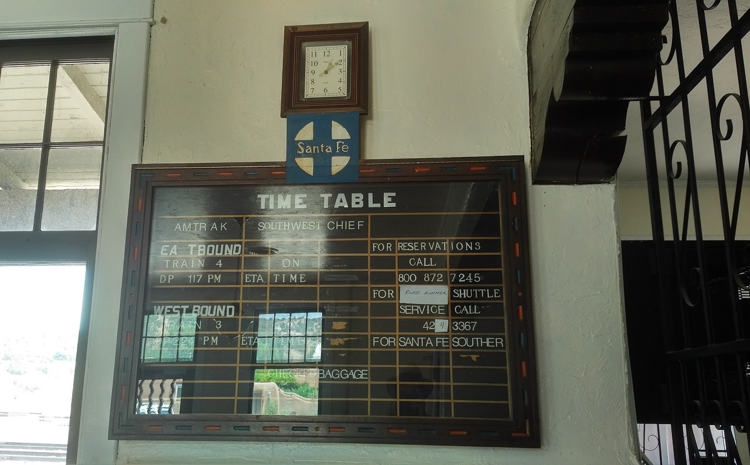 Santa Fe railroad time board featuring elegant wood carving.
