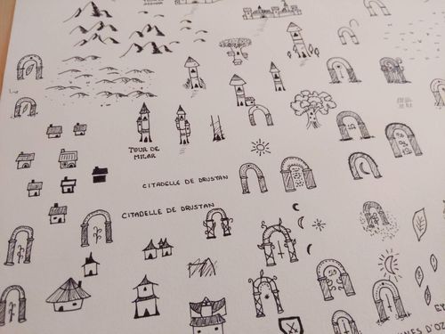 Aperçu d'un brouillon sur papier Canson avec plein d'itération de dessins de lieux (villes, tours, portes...)