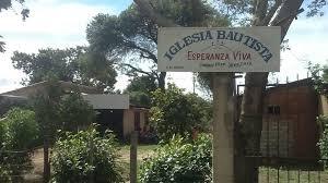 Imagen del letrero frontal de la iglesia, con la iglesia de fondo