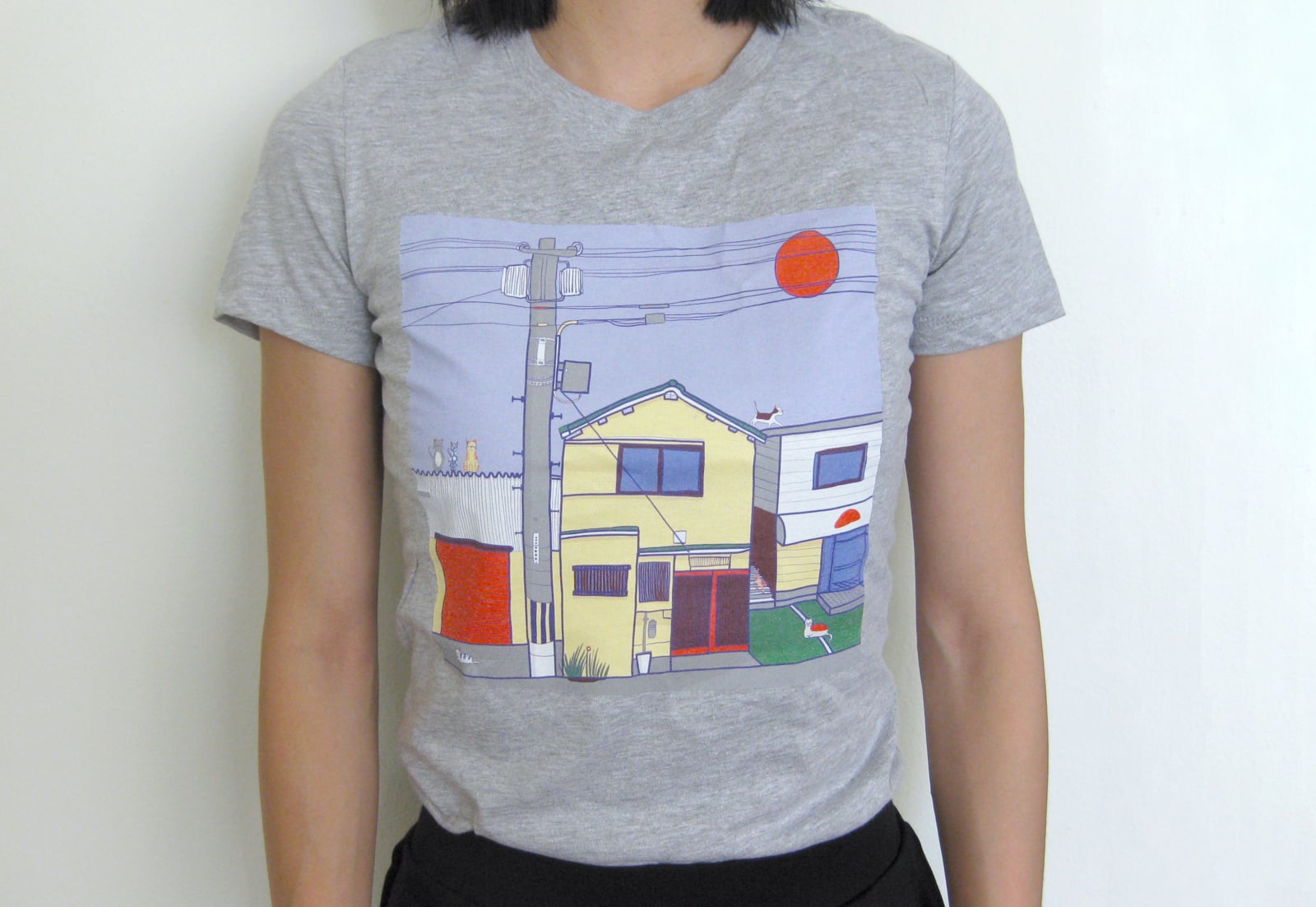 A grey T-shirt. There is an illustration of an Urban Japanese environment with several cats depicted.