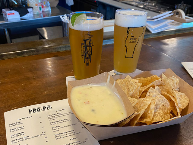 A pair of beers and some chips and house-made queso at the bar at Prohibition Pig in Waterbury, Vermont