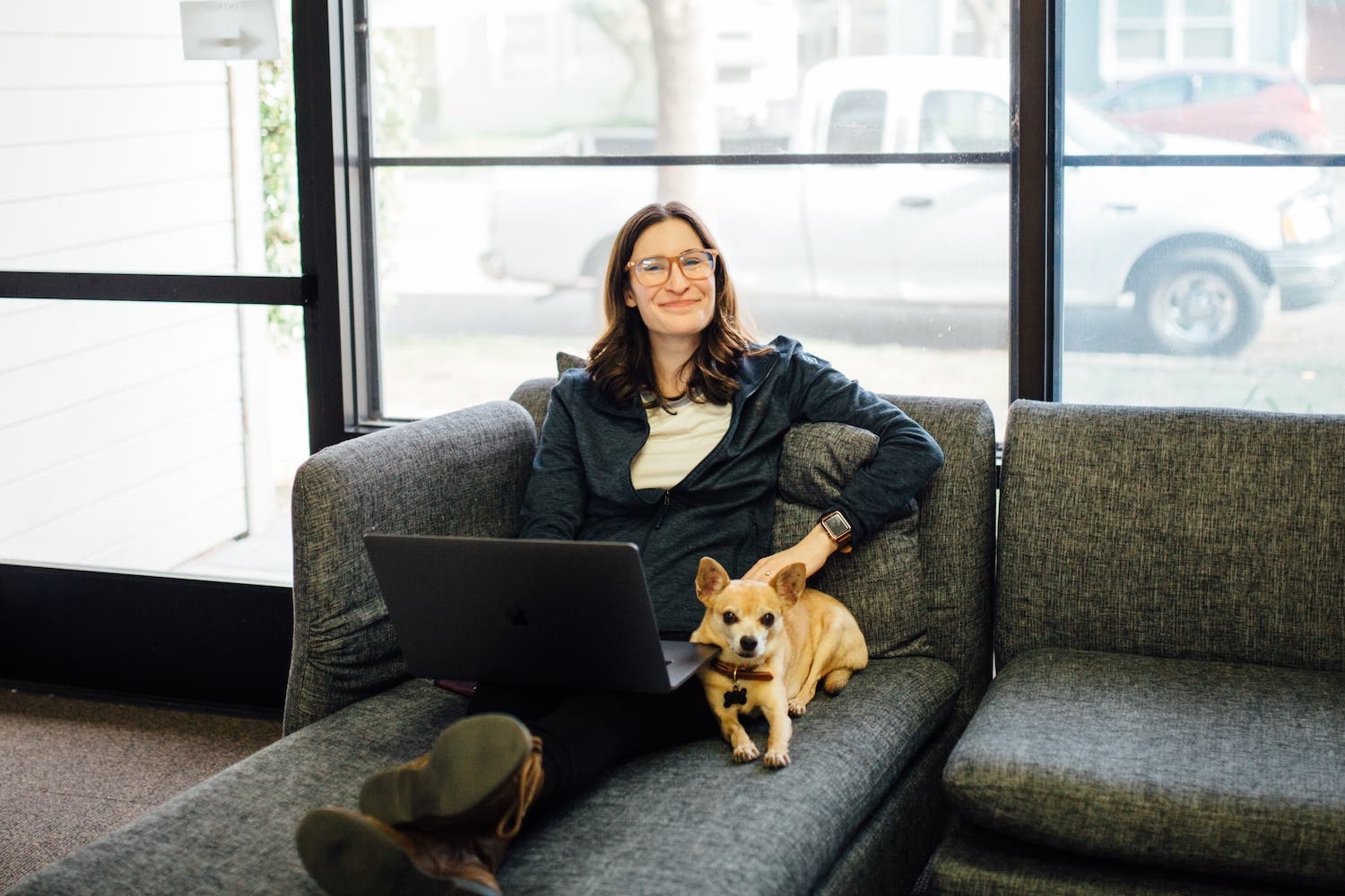 Employee working on at couch with a dog next to them