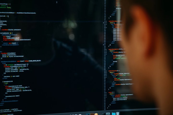 Man Looking At Programming Code On Screen