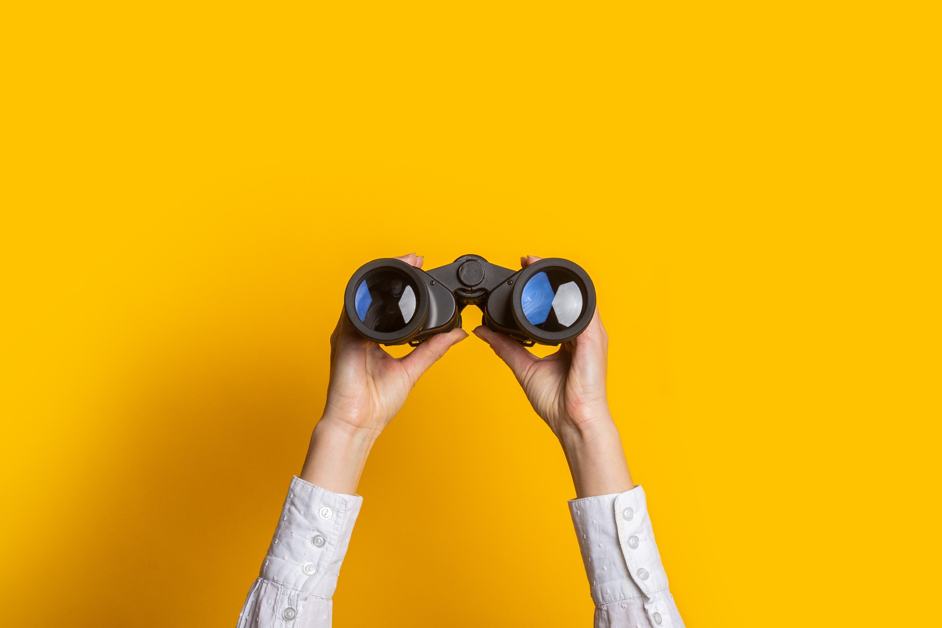 Binoculars with a yellow background