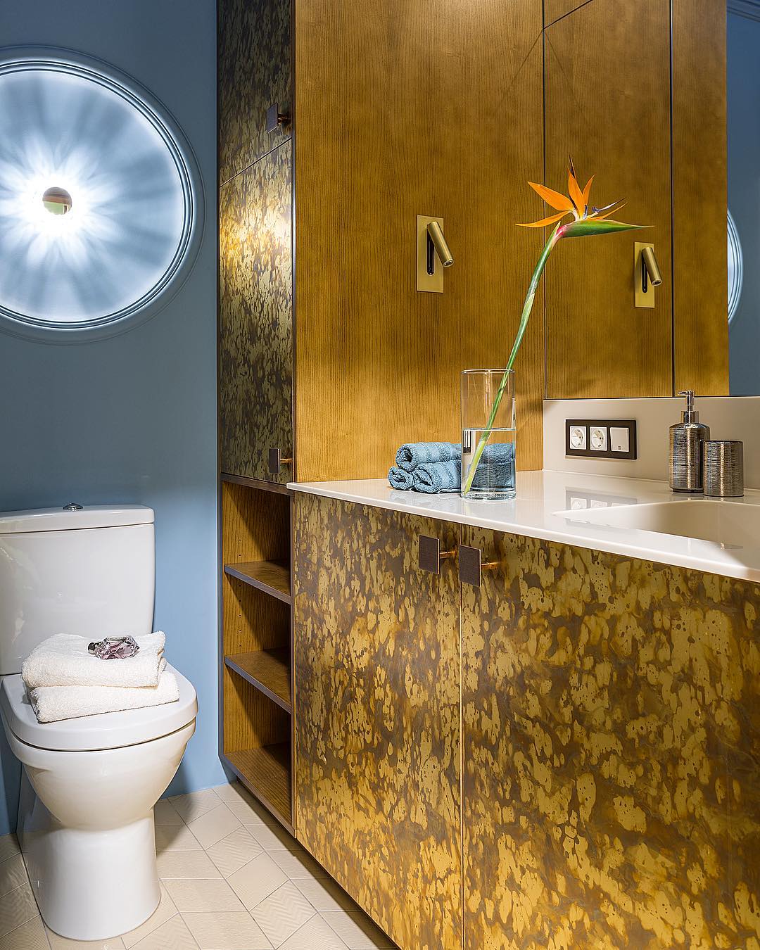 Make Interiors | Такая смелая ванная комната в проекте #tropical_holiday65 🛁 Шкаф для хранения и стиральной машинки под раковиной облицован металлическими панелями👍🏻 А весь корпус выполнен из дерева! В боковины встроены латунные светильники от @astrolighting Светильник над унитазом мы придумали так: чтобы лучи от лампочки прервать💡, встроили в стену диск из полиуретана. Получилась своеобразная форма солнца ☀️ ! #makeinteriors А вам нравится ванная комната?!!😉
