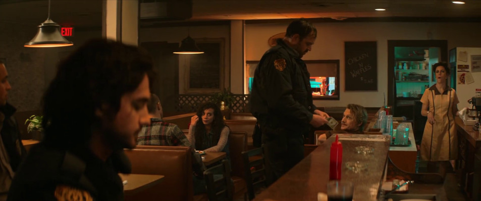 A still from Resident Evil: Welcome to Racoon City showing the majority of the principle actors for the first half of the films, all socially distancing in a diner.