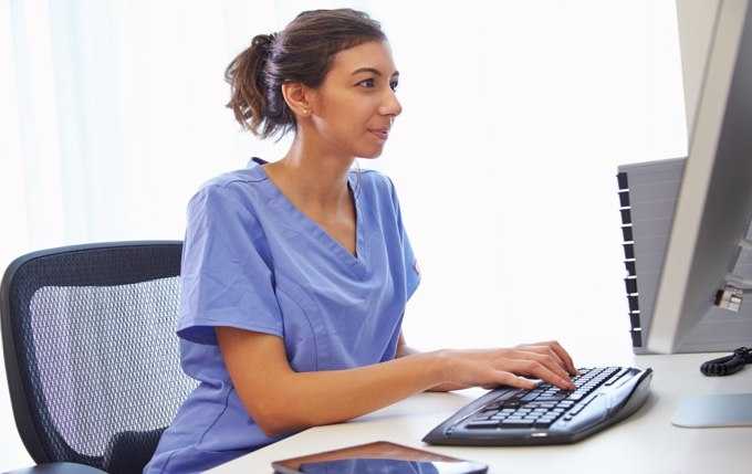 A healthcare professional working on a computer.