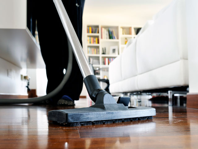 A house cleaner vacuuming a room as a side job
