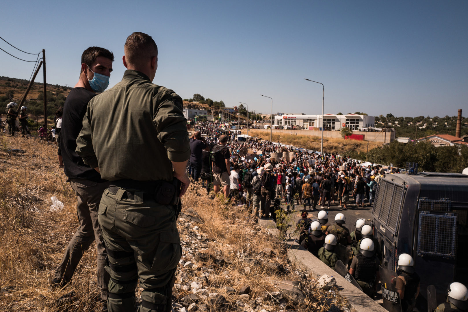 Die griechische Polizei beobachtet einen Protest von Flüchtlingen aus dem Lager Moria. Foto: Nicola Zolin