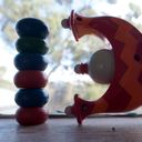 A stack of coloured wooden beads on a window sill alongside a Ninky Nonk toy. Together form the digits of thirteen.