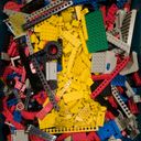 A pile of Lego bricks in the midst of which a cluster of yellow bricks forms the digit one.