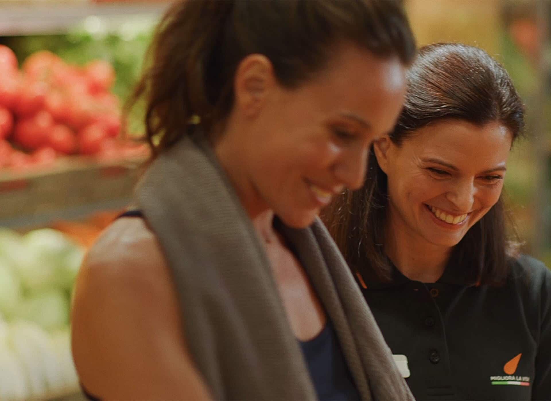 due donne sorridenti al supermercato